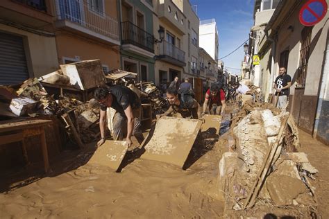 cleaning mud Spain|Volunteers clean flood debris in a Spanish town .